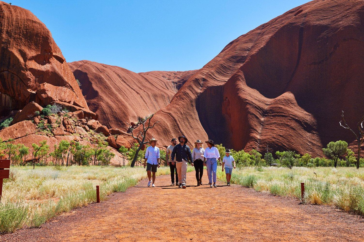 People walking on the Desert Awakenings Tour around Uluru