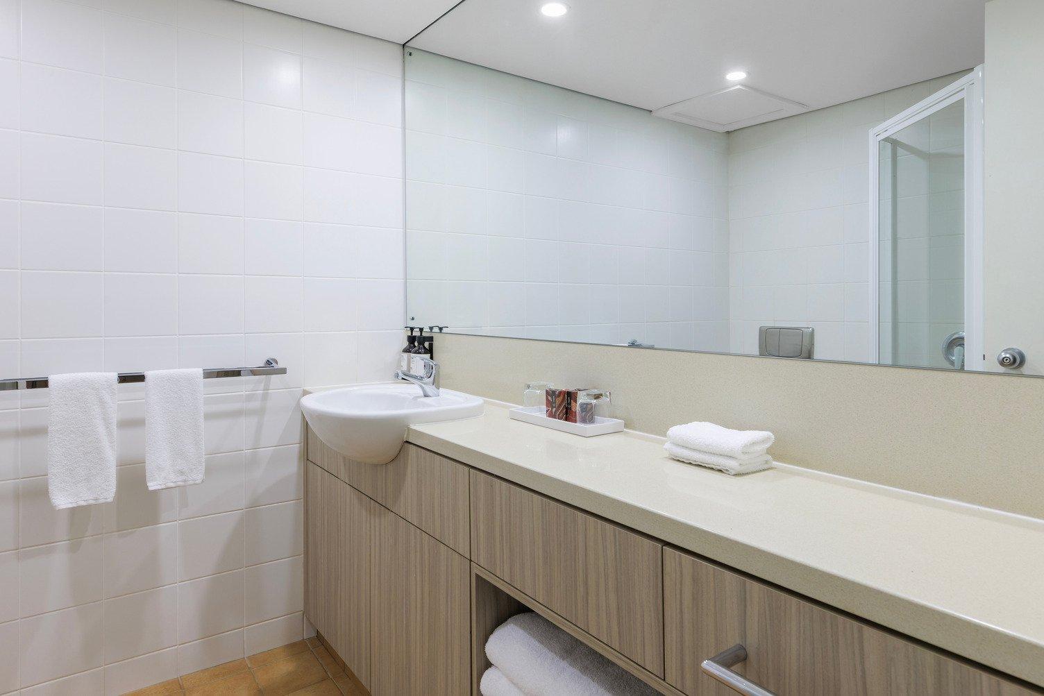 Bathroom with large mirror, single sink, clear shower