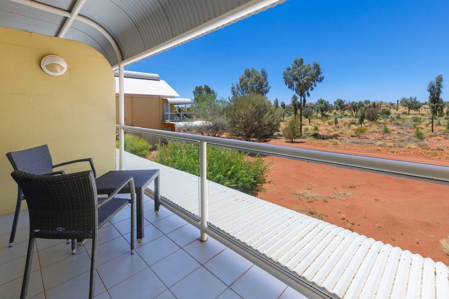 Balcony overlooking the desert landscape with chairs and a table