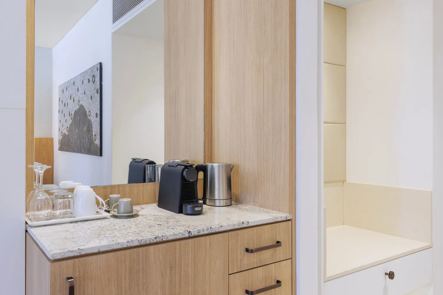 Kitchenette featuring a kettle, a pod coffee machine, with glasses and mugs
