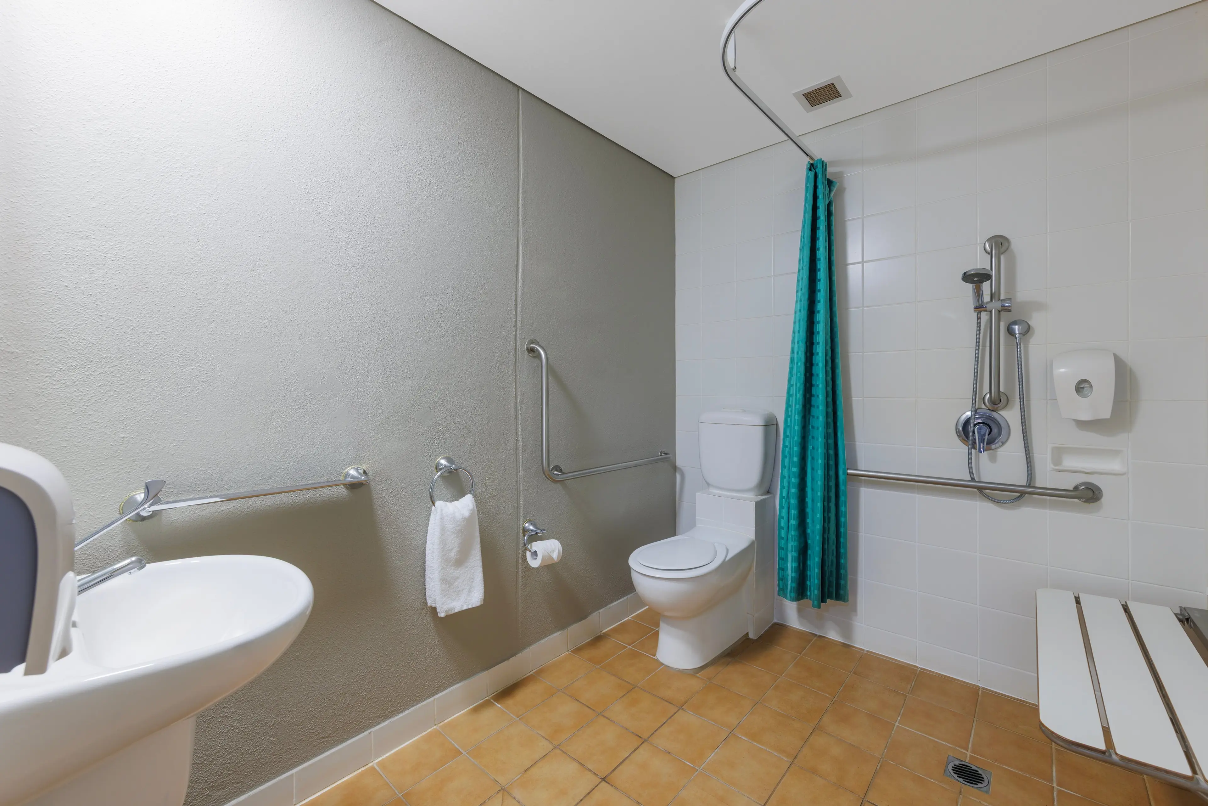 Sink, shower with curtain and toilet