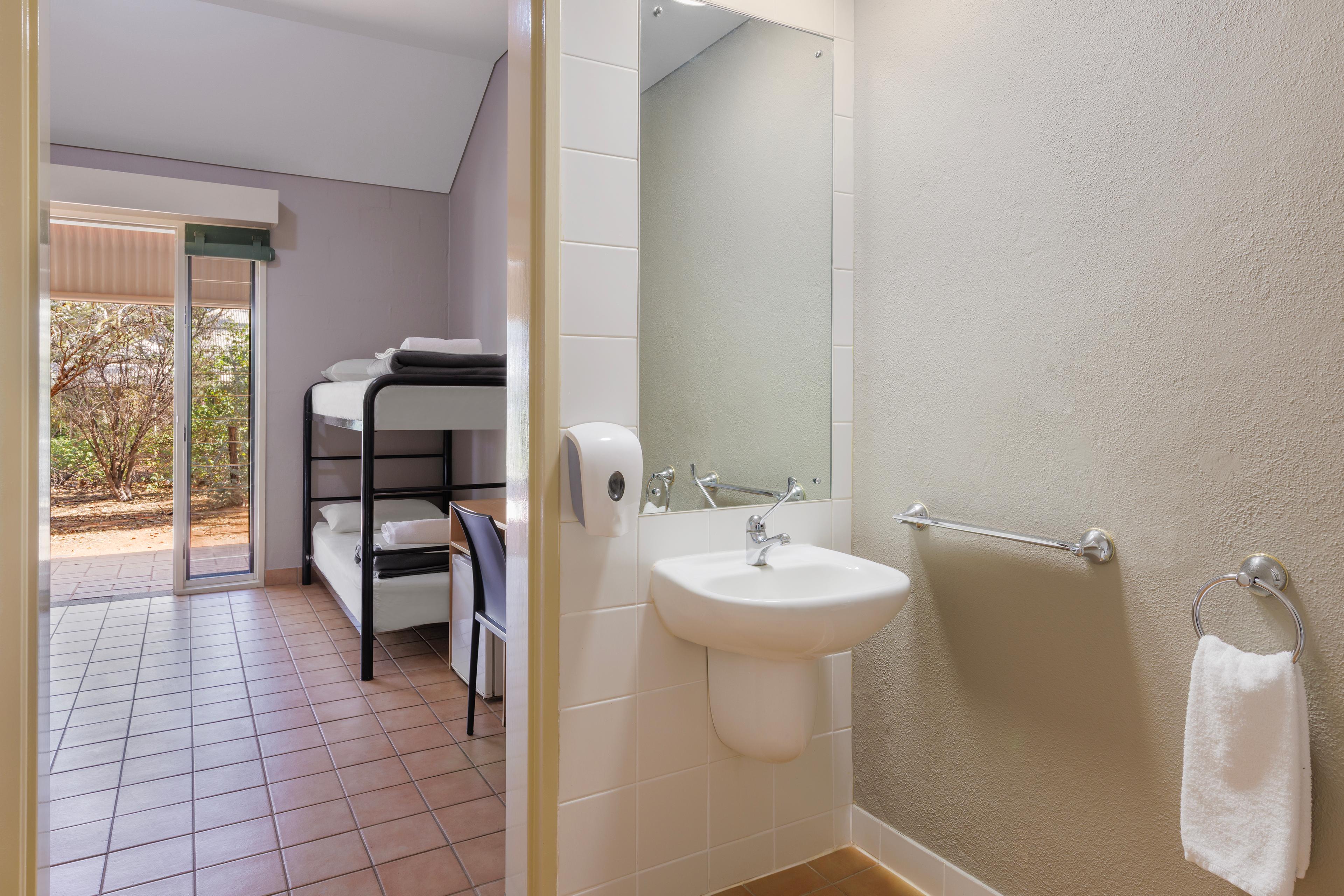 Sink with mirror looking into the room with bunk bed