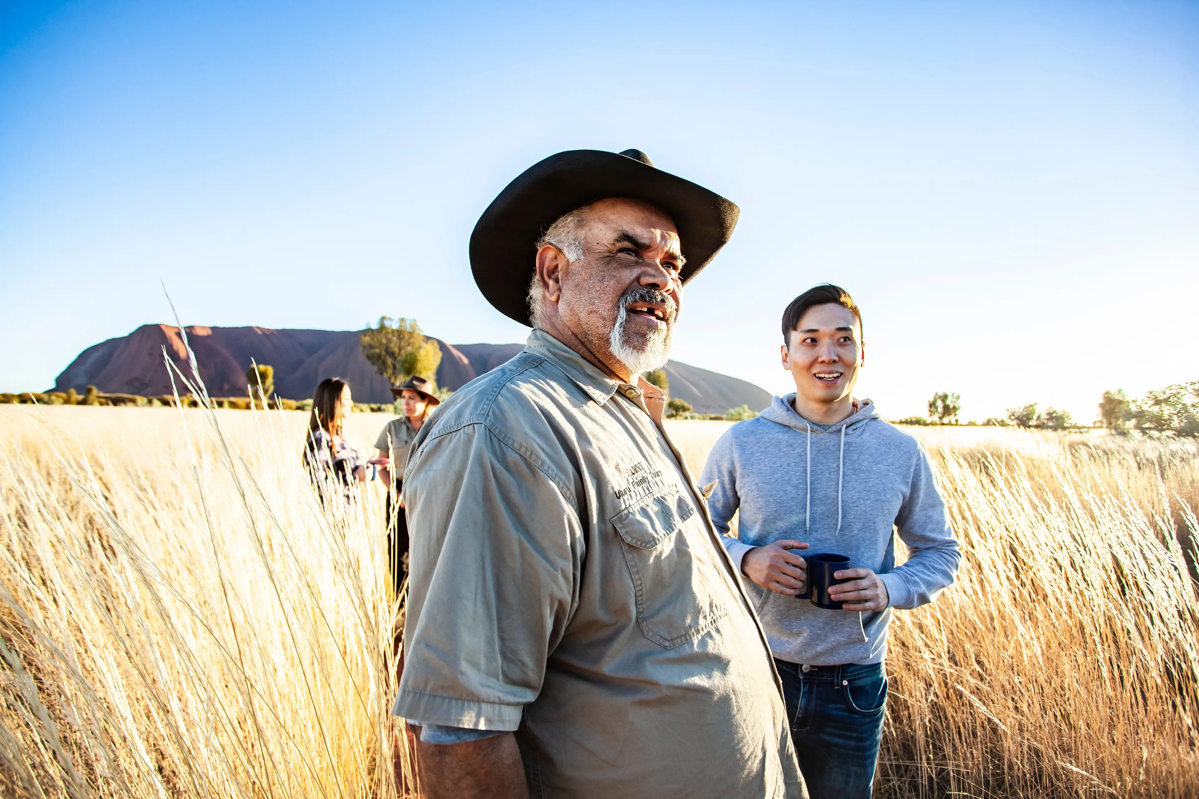 people with guide in front of Uluru