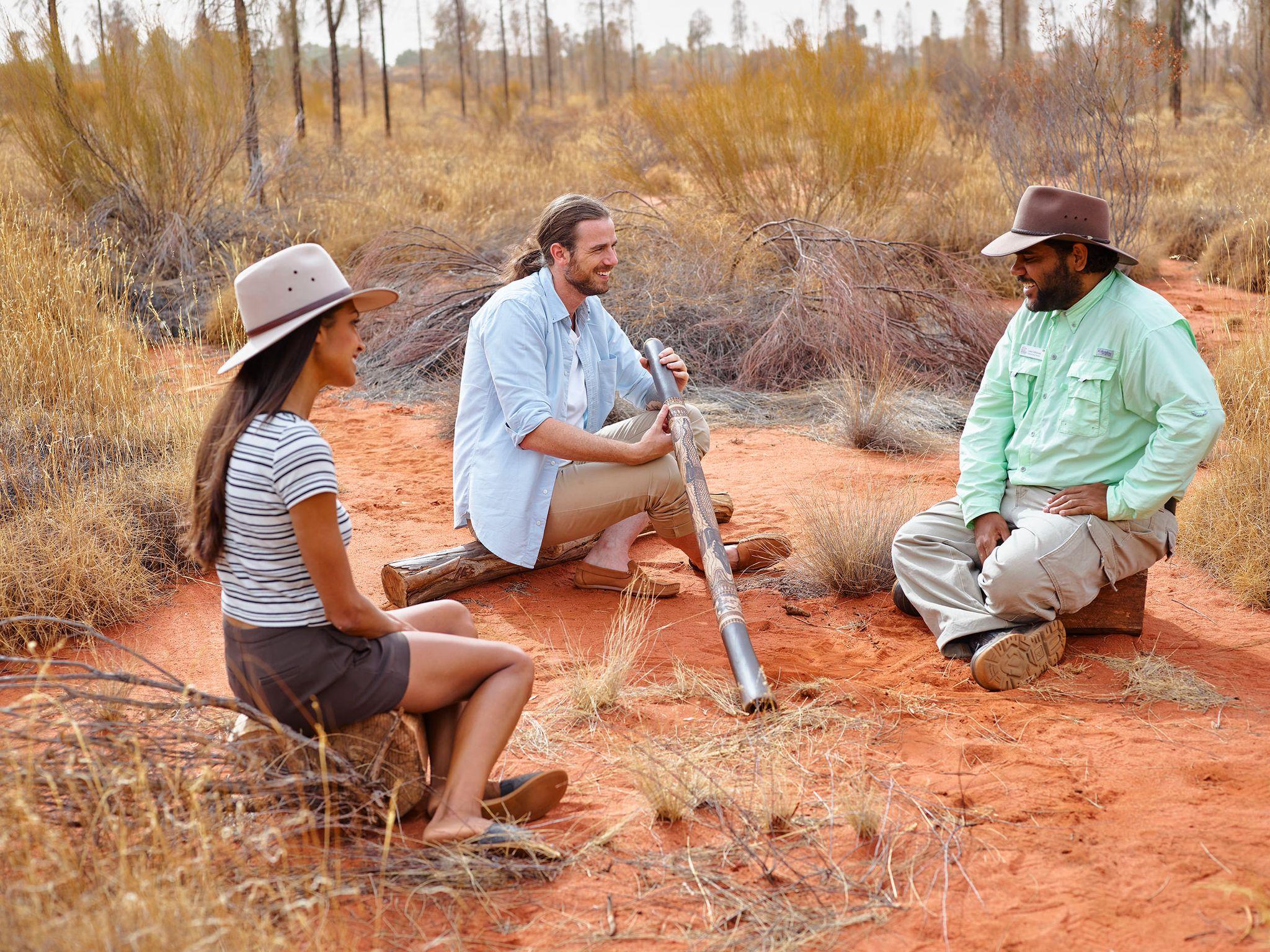 Man in outback learning to play didgeridoo