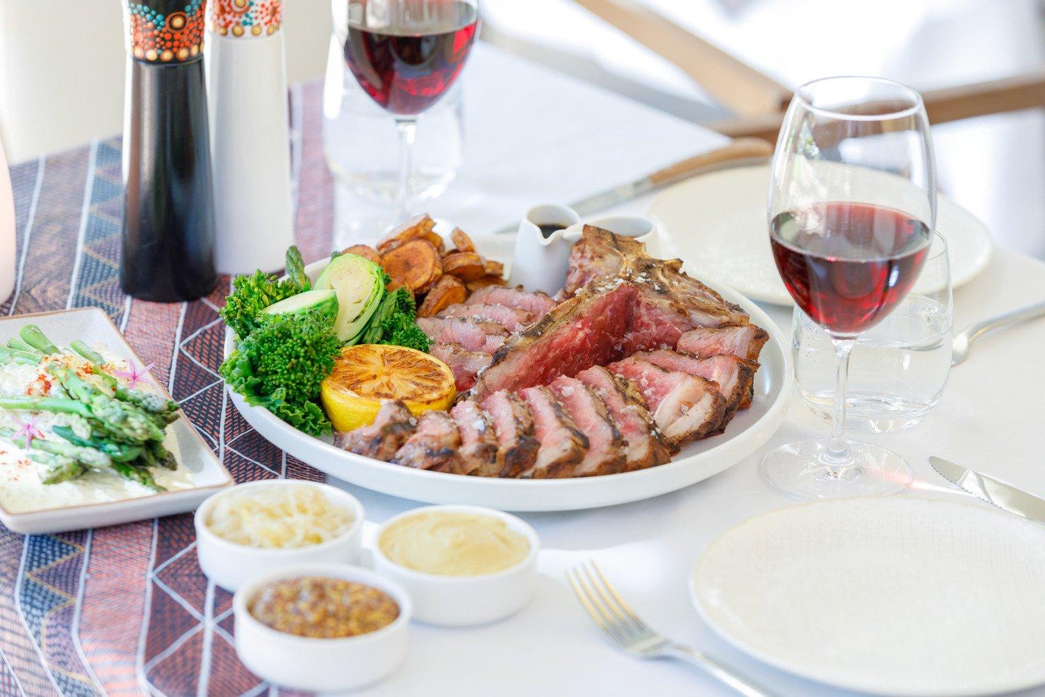 A beautifully curated meal in a bowl with red wine and three sauces at Arnguli Grill