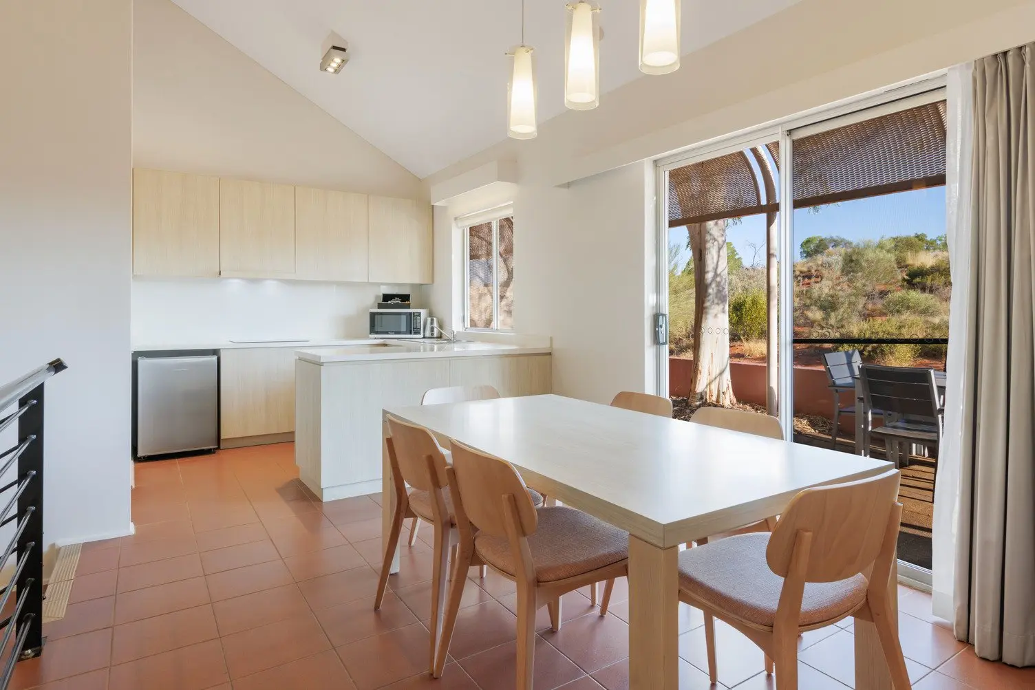 Kitchen and dining area with table and 6 chairs looking out toward the desert landscape