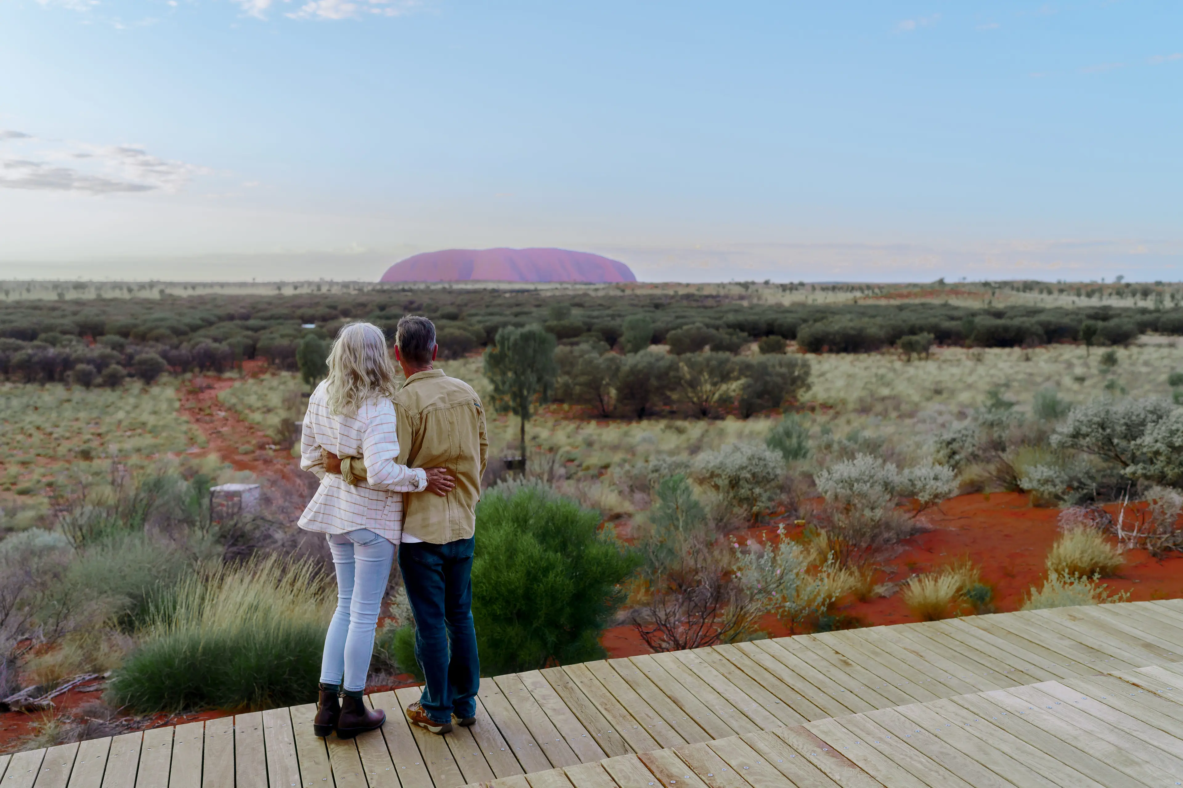 A couple looking at Uluru from a deck at Ayers Rock Resort