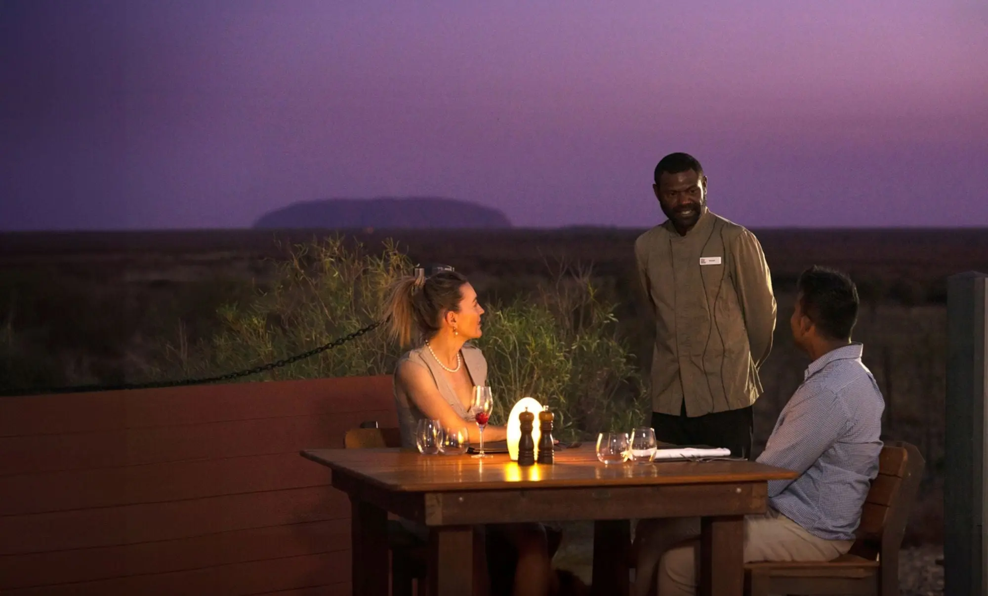 A couple dining at Tali Wiru at Ayers Rock Resort, in front of Uluru