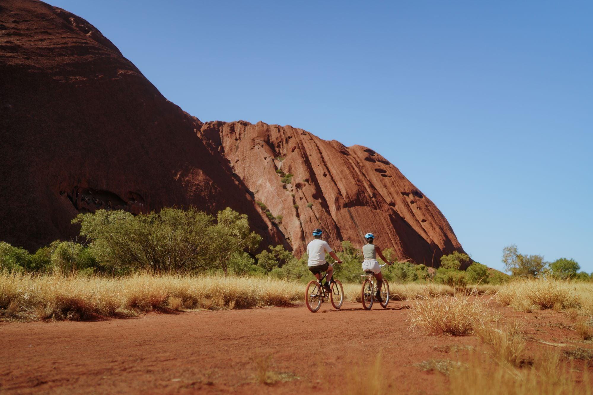 Couple bike riding around Uluru