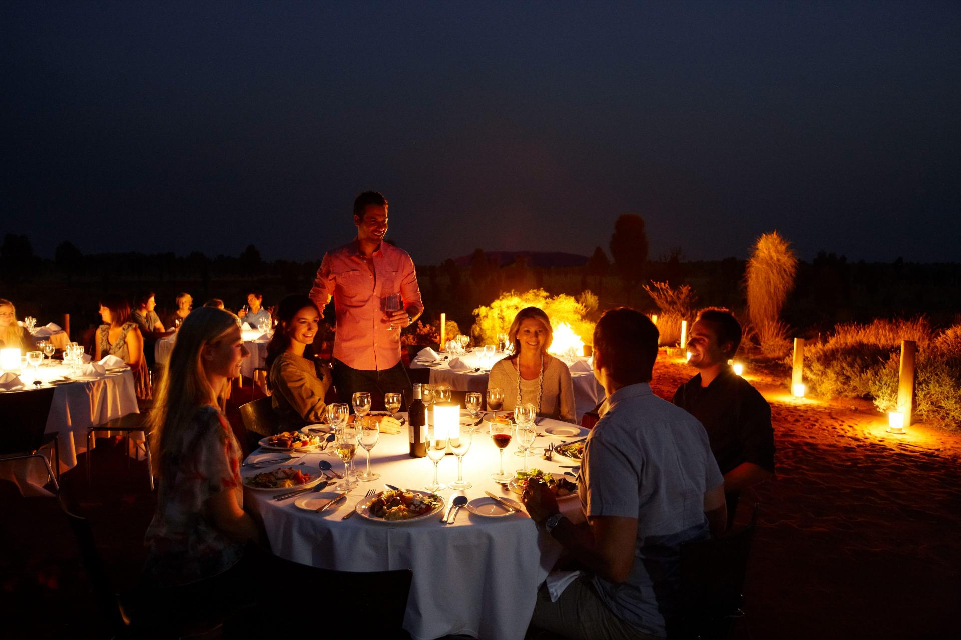 A group of friends enjoying dinner around a table at the Sounds of Silence experience.