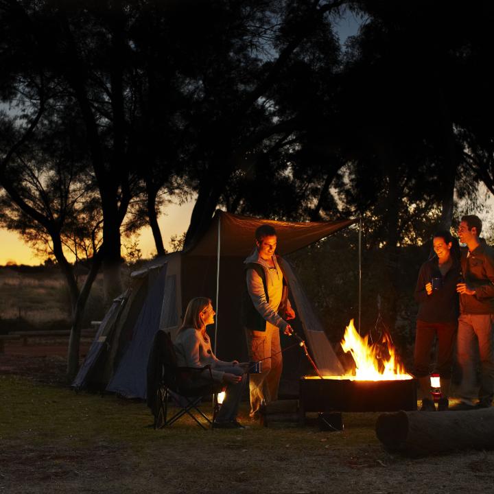 Group camping at night by a fire